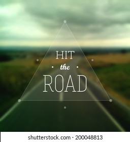 "Hit the Road" poster. Text in a triangle on a defocused road stretching to the horizon. EPS10 vector inage.