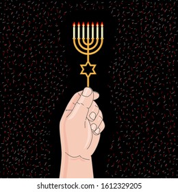 Holding a menorah with burning candles. Black background