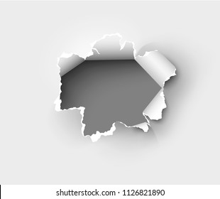 Hole torn in ripped paper on white background