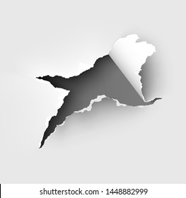 Hole torn in ripped paper on white background