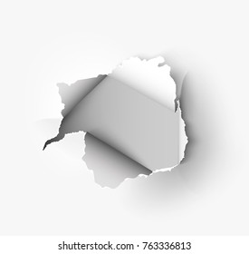 Hole torn in ripped paper on white