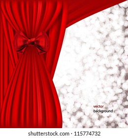 Holiday background with red satin and blurred lights.