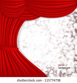 Holiday background with red satin and blurred lights.