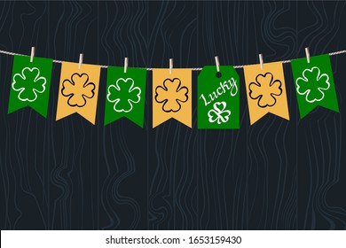 Holiday Decorations for St. Patrick's Day.Vector Stock Illustration with flags on clothespins and the label "Luck"on a green wooden texture background. Irish style interior decoration.