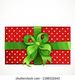 Holiday gift in red box with pattern in white peas and green bow isolated on a white background