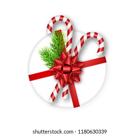 Holiday round gift box with red bow, fir tree branches and candy canes on white background. Template for a banner, poster, invitation. Vector illustration for your design