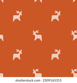 Holiday themed little reindeer silhouettes forming an abstract pattern in a color palette of cream on an orange background. Christmas seamless vector pattern. Great for home decor, fabric, wallpaper.