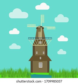 Holland windmill near canal with green grass around