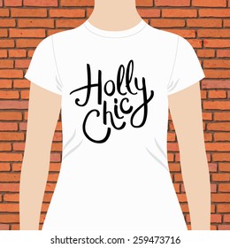 Holly Chic t-shirt template design with simple elegant black writing on the chest of a white top modeled on a person against a red brick wall, vector design