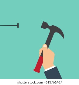 Concepto de reparación de viviendas. El hombre marea un clavo en una pared. Trabajos de construcción de plantillas. Sujetando un martillo en la mano.