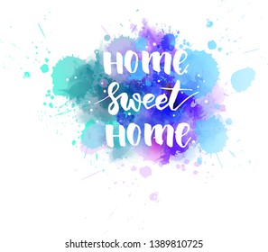Home sweet home - handwritten modern calligraphy lettering text on abstract watercolor paint splash background. Blue and purple colored.