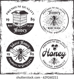 Honey set of four vector round black badges, labels or emblems in vintage style on white background with removable grunge textures