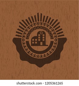 hospital icon inside badge with wood background