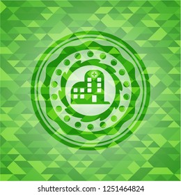 hospital icon inside green emblem with triangle mosaic background