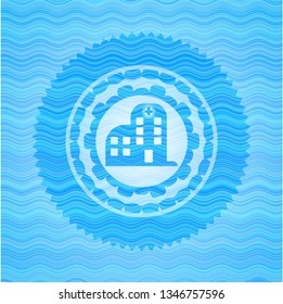 hospital icon inside light blue water style badge.