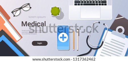 hospital worker table online mobile app top angle view doctor workplace desktop with laptop smartphone stethoscope and clipboard office stuff copy space horizontal