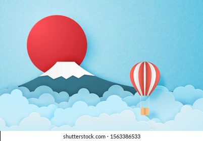 Hot air balloon floating in the sky and Fuji mountain and the sun in paper cut style. Digital craft paper art. Travel concept.