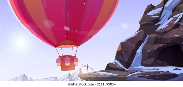 Hot air balloon tied near cave in mountains. Vector cartoon illustration of winter rocks landscape with stone cavern, snow and colorful airship with basket and ballast