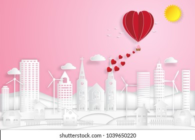 The hot air heart balloon, sun and cityscape on pink sky as love, happy valentine's day, wedding and paper art concept. vector illustration.