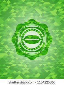 hot dog icon inside green emblem with mosaic background