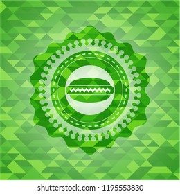 hot dog icon inside green emblem with mosaic background