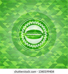 hot dog icon inside green emblem with mosaic background