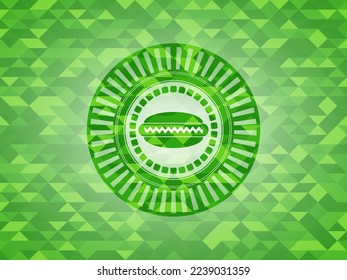 hot dog icon inside green emblem with triangle mosaic background. 