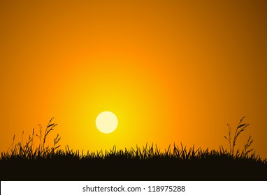 The hot glowing sun sets behind a hill silhouetting the field grass.