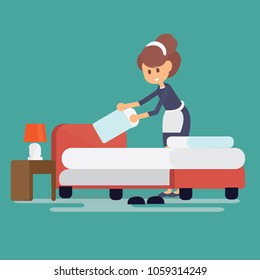 Hotel maid setting up pillow on bed sheet in hotel room