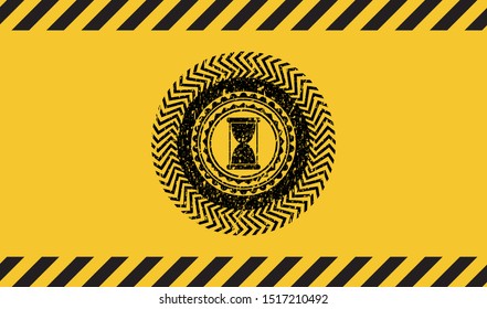 hourglass icon black grunge emblem with yellow background. Vector Illustration. Detailed.