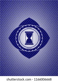 hourglass icon inside badge with denim texture