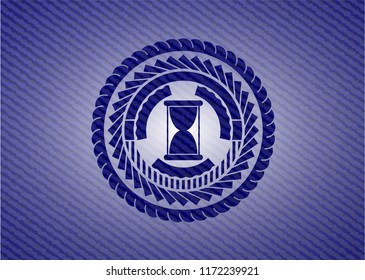 hourglass icon inside badge with denim background