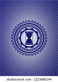 hourglass icon inside badge with denim background
