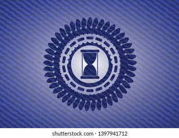hourglass icon inside badge with denim background