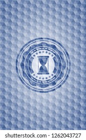hourglass icon inside blue emblem with geometric pattern.