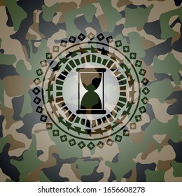 hourglass icon inside camouflaged emblem