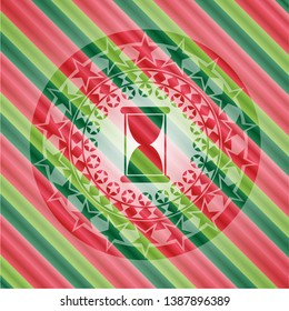 hourglass icon inside christmas colors badge.