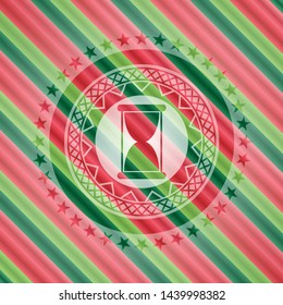 hourglass icon inside christmas colors style badge.