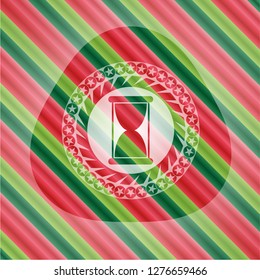 hourglass icon inside christmas emblem.