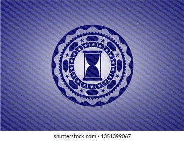 hourglass icon inside emblem with denim high quality background