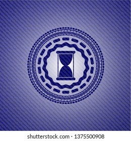 hourglass icon inside emblem with denim high quality background