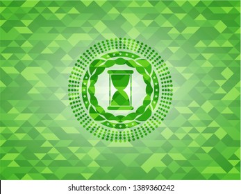 hourglass icon inside green emblem. Mosaic background
