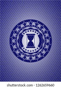 hourglass icon inside jean or denim emblem or badge background