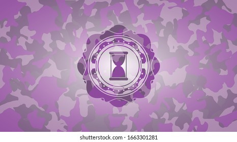 hourglass icon inside pink camo emblem