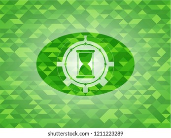 hourglass icon inside realistic green emblem. Mosaic background