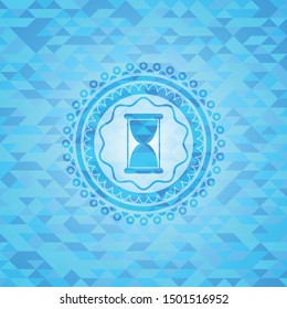 hourglass icon inside realistic light blue emblem. Mosaic background
