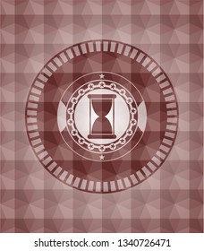 hourglass icon inside red seamless emblem with geometric background.