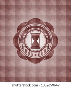 hourglass icon inside red seamless emblem with geometric pattern.
