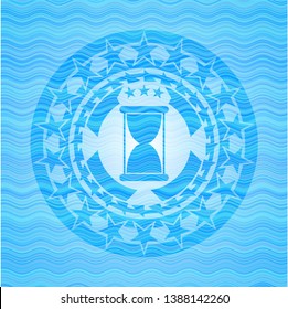 hourglass icon inside water wave representation style badge.