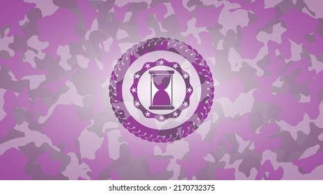 hourglass icon on pink and purple camo texture. 